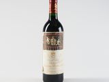 a bottle of red wine sitting on top of a white table