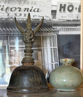 two vases sitting on a table with a picture in the background