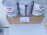 three cans of paint sitting on top of a cardboard box