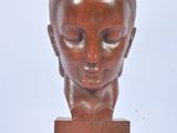 sculpture of a woman ' s head on a wooden base