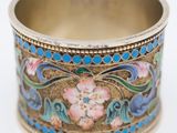 a close up of a ring with flowers on it on a white surface