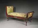 un banc rouge dont l'assise est recouverte d'un tissu jaune et vert