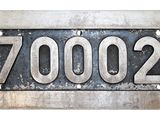 un gros plan d'une plaque métallique sur laquelle est inscrit le chiffre 7000