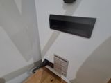 a white refrigerator with a black door and a wooden floor