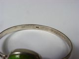 silver bracelet with a green stone in the middle of it