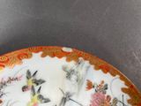 a plate with a design of birds and flowers on it