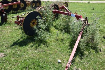 a tractor that is sitting in the grass with a plow