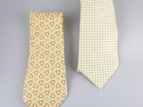a pair of yellow and white neck ties on a gray background