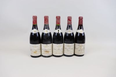 quatre bouteilles de vin sont alignées sur une surface blanche