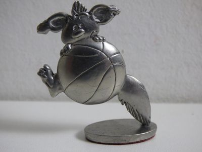 une figurine en argent représentant un chien jouant avec un ballon de basket