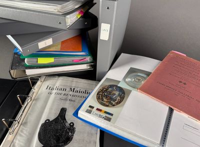 a stack of books on a desk next to a printer