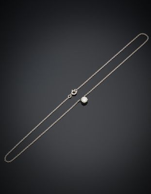 un collier en argent orné d'une perle et d'une chaîne, sur fond noir