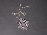 pendentif en forme de croix en argent avec une chaîne, sur un fond noir