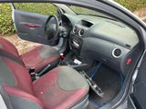 the interior of a small car with red seats and a steering wheel