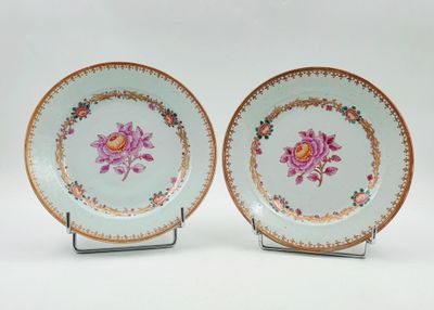 deux assiettes ornées de fleurs sont posées sur un support en métal