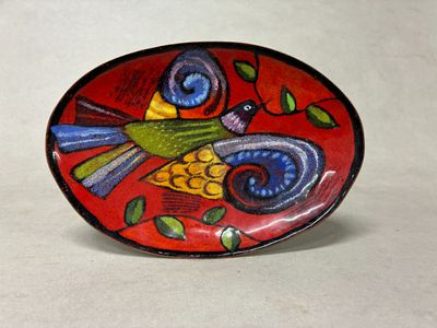 une assiette rouge sur laquelle est peint un oiseau