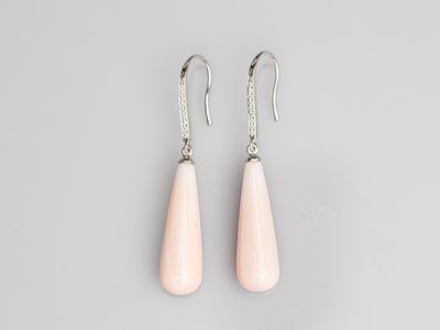 a pair of pink stone earrings on a grey background