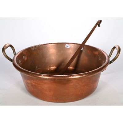 une vieille casserole en cuivre avec des pinces et des poignées, sur fond blanc