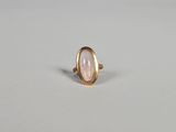 une bague en or avec une pierre rose au centre