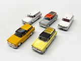 several toy cars are lined up in a row on a white surface