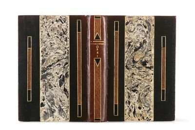 un vieux livre à la couverture noire, rehaussée de dorures sur fond blanc