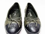 pair of black and green shoes with laces on them on a white surface