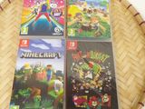 trois jeux Nintendo Wii posés sur un panier posé sur une table