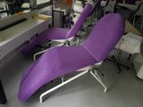 a purple chaise lounger in a room with a computer desk