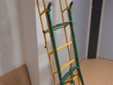 une échelle jaune et verte appuyée contre un mur blanc dans une pièce