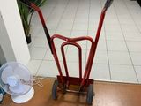 a red hand truck that is sitting in the middle of a room