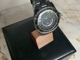 black watch on a black stand on a marble counter top