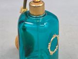 a blue glass bottle with a gold cap on it
