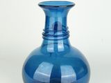 a blue vase that is sitting on a white surface