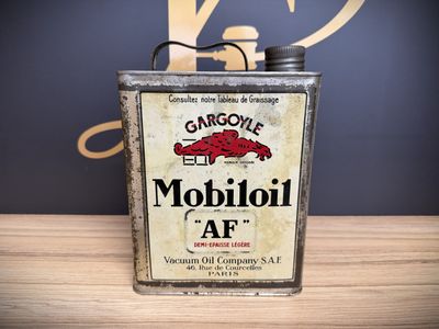 an old metal can with a sign on it sitting on a table