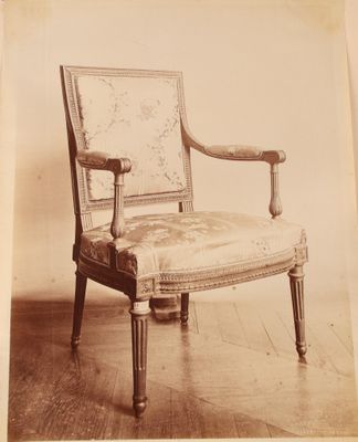 une vieille photo d'une chaise dont l'assise est recouverte d'un tissu à motifs floraux