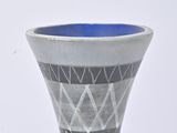 a silver vase with a black and white design on it