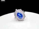 a close up of a ring with a blue stone surrounded by diamonds