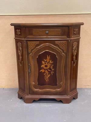 a small wooden cabinet with a flower design on it