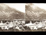 a black and white photo of a town with mountains in the background