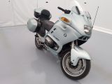 a white motorcycle parked in a room with a white wall