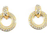 une paire de boucles d'oreilles en or et diamants sur fond blanc