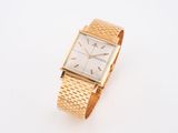 an image of a gold watch on a white surface