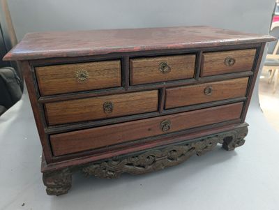 une petite commode en bois posée sur une table