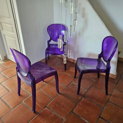 trois chaises violettes dans une pièce au sol carrelé de rouge