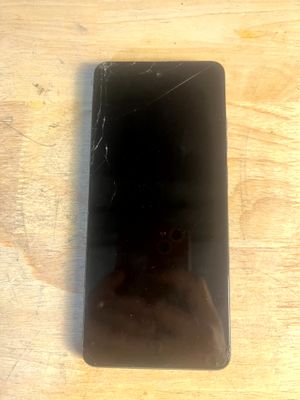 un téléphone portable cassé posé sur une table en bois