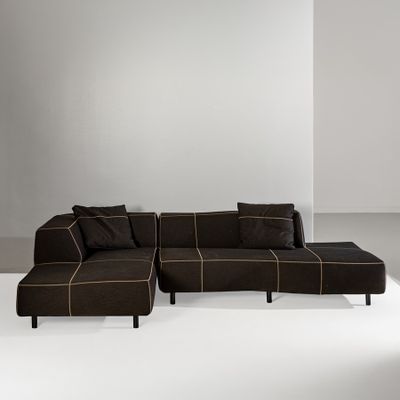 a large brown sectional couch sitting on top of a white floor