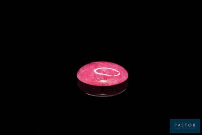 a pink candle that is lit up in the dark