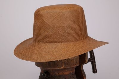 un chapeau marron posé sur un support en bois