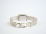 a close up of a silver bracelet with a clasp on a white background
