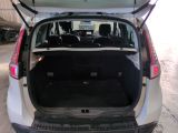 the back of a white car with its trunk open in a garage